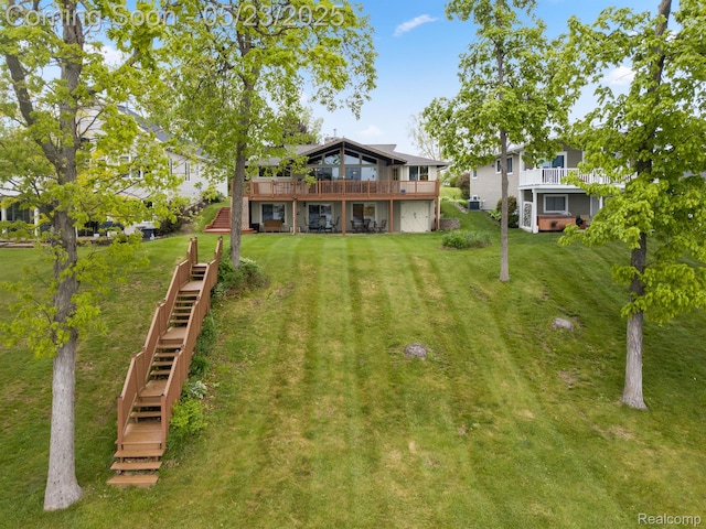 13953 Grandpoint Dr, Cement City, MI 49233 - back of house with stairway, a yard, a wooden deck, and a garage