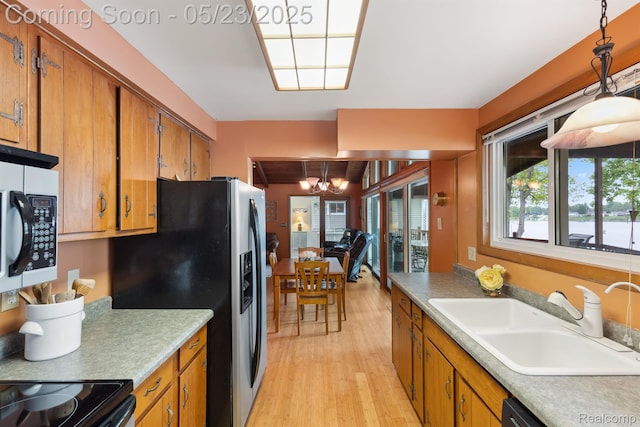 13953 Grandpoint Dr, Cement City, MI 49233 - kitchen with a sink, a chandelier, brown cabinets, light wood-style flooring, and stainless steel refrigerator with ice dispenser