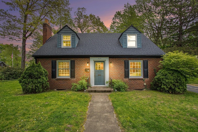 424 S Cass St, Berrien Springs, MI 49103 - cape cod house with a chimney, brick siding, a front yard, and a shingled roof