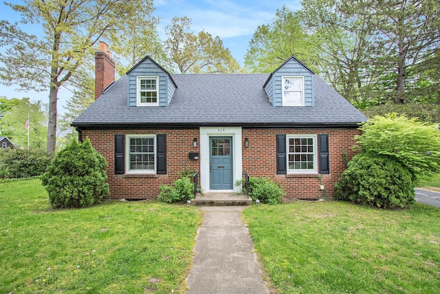 424 S Cass St, Berrien Springs, MI 49103 - cape cod house featuring a chimney, brick siding, a front lawn, and roof with shingles