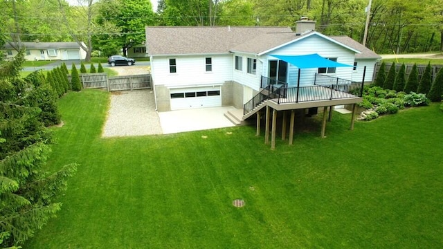 back of house featuring an attached garage, a wooden deck, concrete driveway, and roof with shingles
