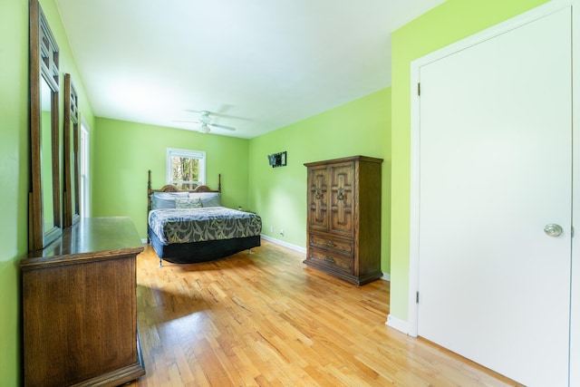 bedroom featuring light wood-style flooring, baseboards, and a ceiling fan