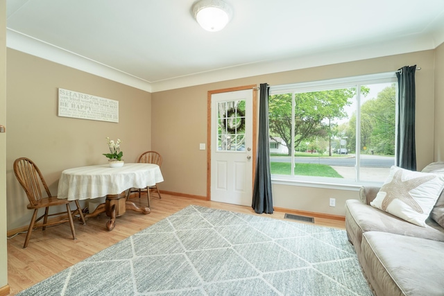 living room with healthy amount of natural light, baseboards, and light wood-type flooring