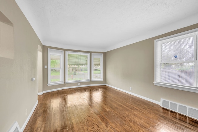 9583 Stahelin Ave, Detroit, MI 48228 - unfurnished room with plenty of natural light, wood finished floors, baseboards, and a textured ceiling
