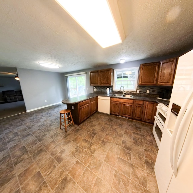 5734 108th Ave, Pullman, MI 49450 - kitchen featuring white dishwasher, a sink, a peninsula, range, and a textured ceiling