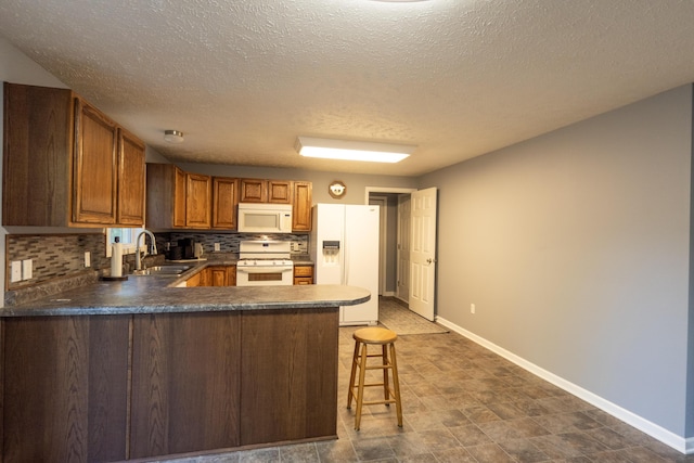 5734 108th Ave, Pullman, MI 49450 - kitchen featuring white appliances, a peninsula, decorative backsplash, dark countertops, and brown cabinets