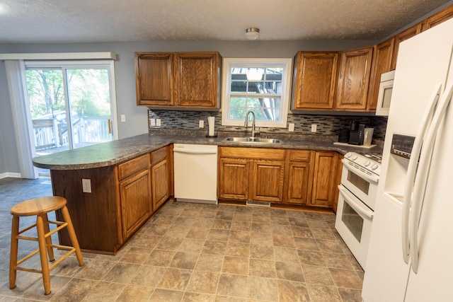 5734 108th Ave, Pullman, MI 49450 - kitchen with white appliances, a peninsula, healthy amount of natural light, dark countertops, and a textured ceiling