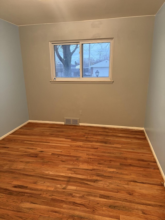 empty room with wood finished floors and baseboards