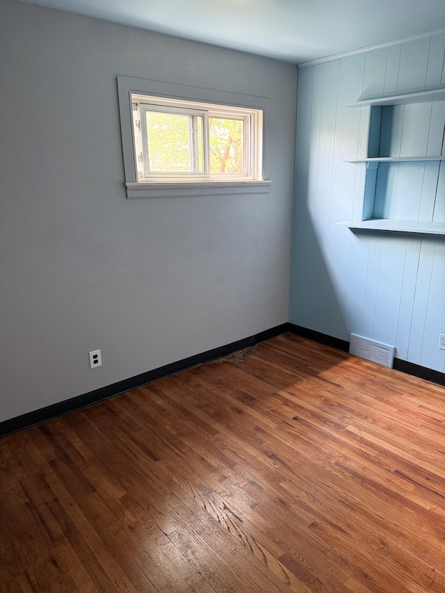 empty room with wood finished floors and baseboards