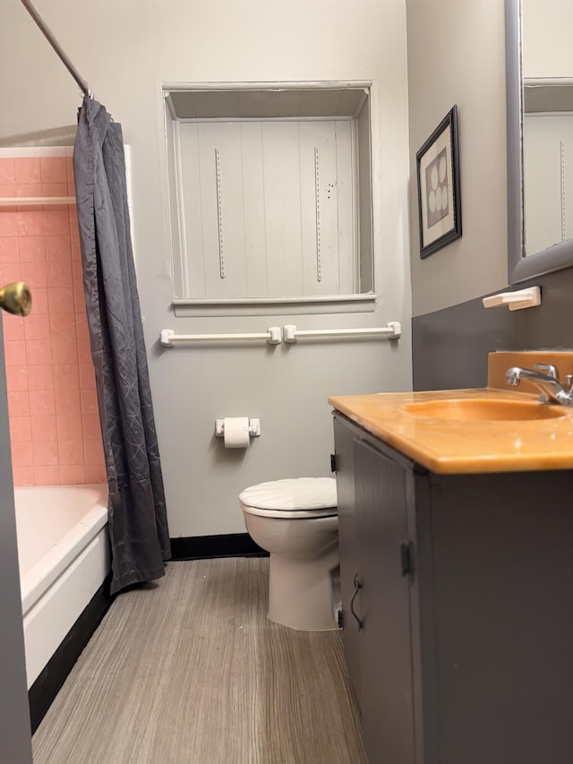 full bath with toilet, vanity, shower / tub combo with curtain, and baseboards