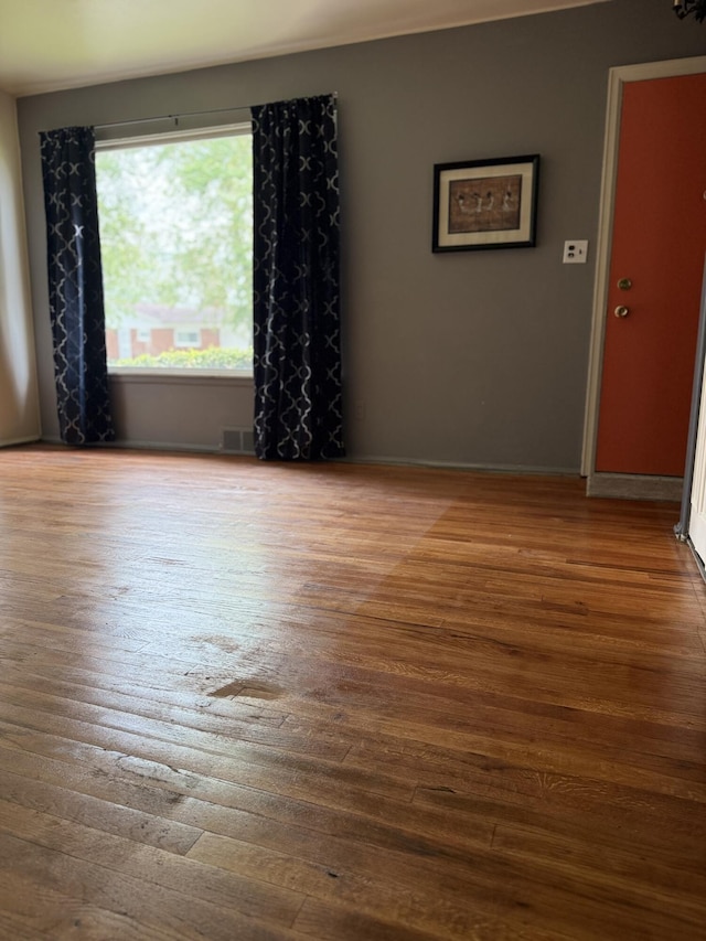 spare room featuring wood finished floors and baseboards