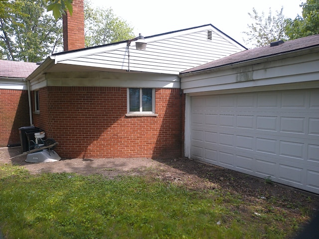 21423 Scotia Ln, Ferndale, MI 48220 - view of side of home featuring a chimney, brick siding, and a garage