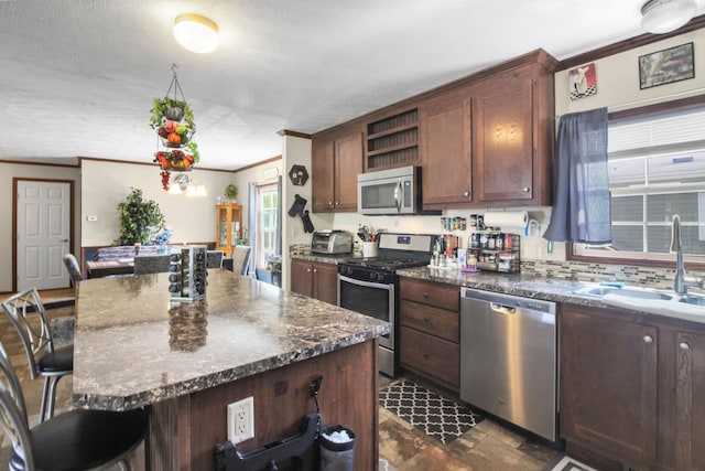 29878 Meadow Ln, Gibraltar, MI 48173 - kitchen featuring stainless steel appliances, a sink, crown molding, a breakfast bar, and open shelves