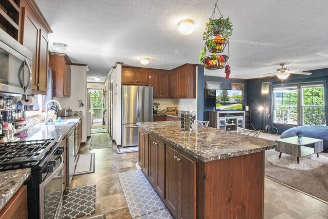 29878 Meadow Ln, Gibraltar, MI 48173 - kitchen with appliances with stainless steel finishes, a sink, healthy amount of natural light, a kitchen island, and a textured ceiling