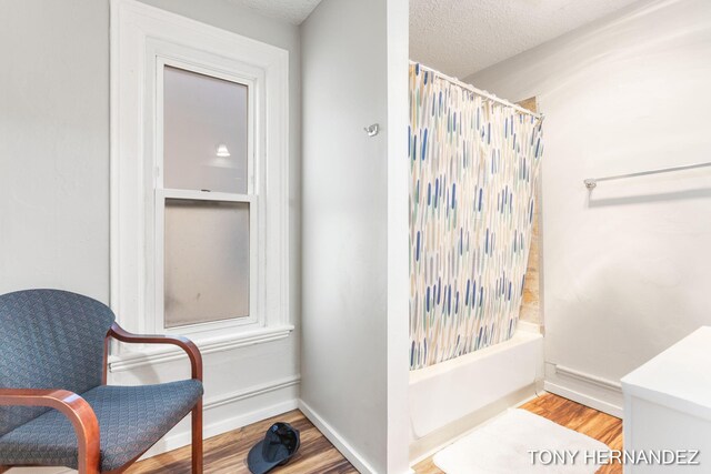 1402 N Ave NE, Grand Rapids, MI 49505 - bathroom with shower / bath combination with curtain, wood finished floors, a textured ceiling, and baseboards