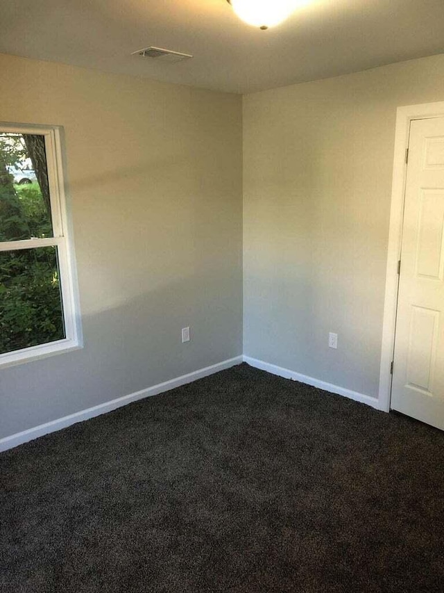 1402 N Ave NE, Grand Rapids, MI 49505 - spare room featuring dark colored carpet and baseboards