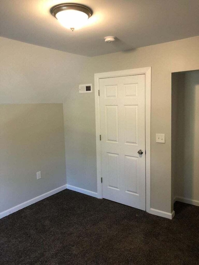 1402 N Ave NE, Grand Rapids, MI 49505 - spare room featuring dark colored carpet and baseboards