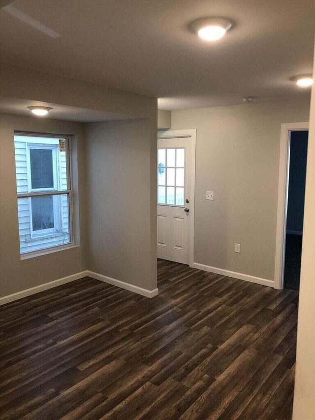 1402 N Ave NE, Grand Rapids, MI 49505 - unfurnished room with baseboards and dark wood-type flooring