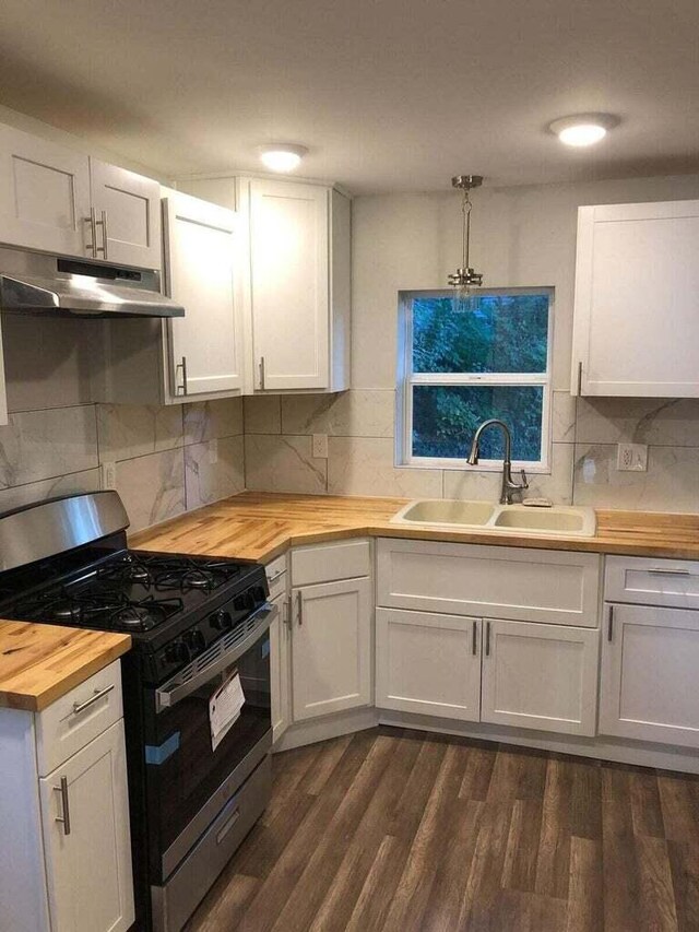 1402 N Ave NE, Grand Rapids, MI 49505 - kitchen with butcher block counters, stainless steel range with gas cooktop, under cabinet range hood, a sink, and dark wood-type flooring