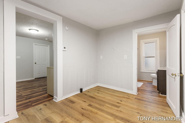 1402 N Ave NE, Grand Rapids, MI 49505 - empty room with light wood-style flooring, baseboards, a textured ceiling, and a smoke detector