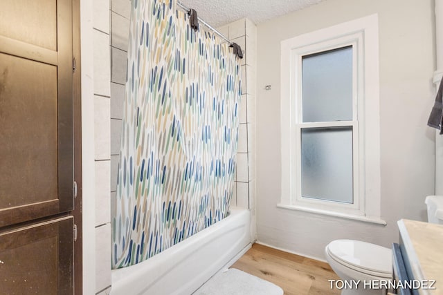 1402 N Ave NE, Grand Rapids, MI 49505 - bathroom featuring vanity, toilet, wood finished floors, shower / tub combo with curtain, and a textured ceiling