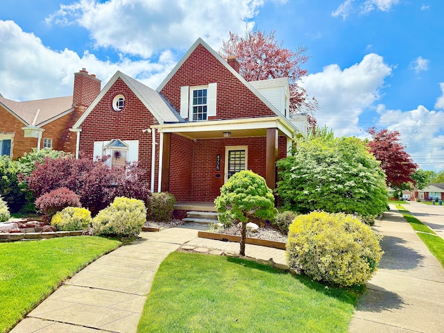 4775 Orchard Ave, Dearborn, MI 48126 - view of front of house featuring brick siding, a chimney, a front yard, and a porch