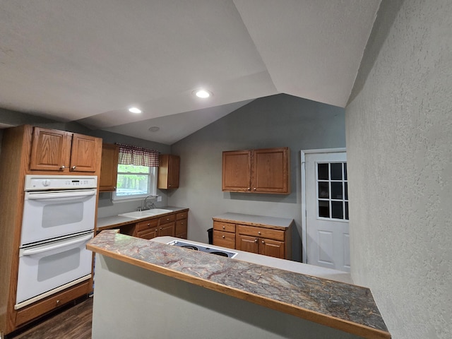 3800 W Hallett Rd, Hillsdale, MI 49242 - kitchen with double oven, tile counters, a textured wall, vaulted ceiling, and a sink