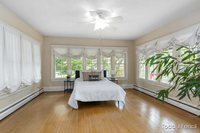 554 Madison Ave SE, Grand Rapids, MI 49503 - bedroom featuring a baseboard heating unit, light wood-style flooring, and baseboards