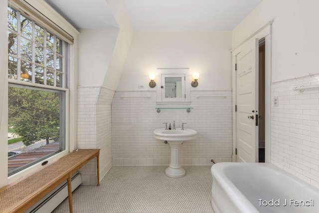 554 Madison Ave SE, Grand Rapids, MI 49503 - bathroom with a baseboard heating unit, tile walls, a soaking tub, tile patterned floors, and wainscoting