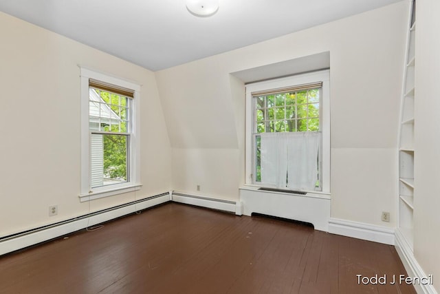 554 Madison Ave SE, Grand Rapids, MI 49503 - spare room featuring wood-type flooring, baseboards, and a baseboard radiator
