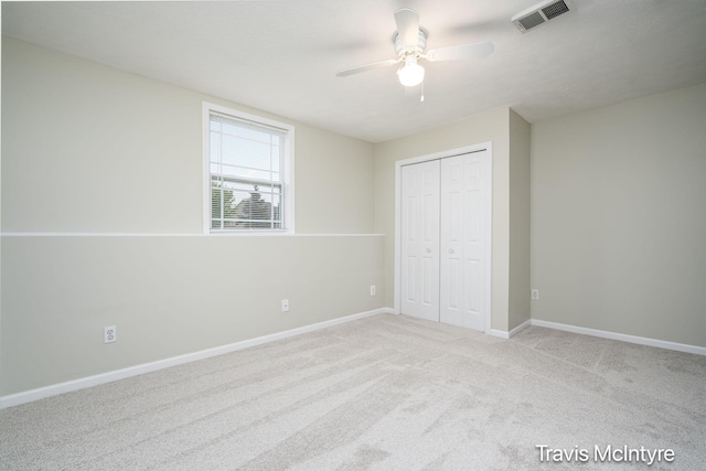 unfurnished bedroom featuring a closet, carpet flooring, baseboards, and ceiling fan