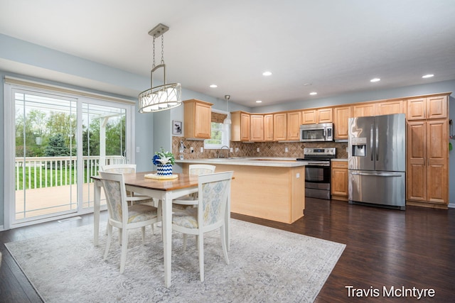 kitchen with appliances with stainless steel finishes, light countertops, dark wood-style flooring, tasteful backsplash, and recessed lighting