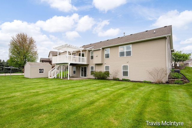 rear view of property featuring a pergola, a yard, a patio, an outbuilding, and stairs