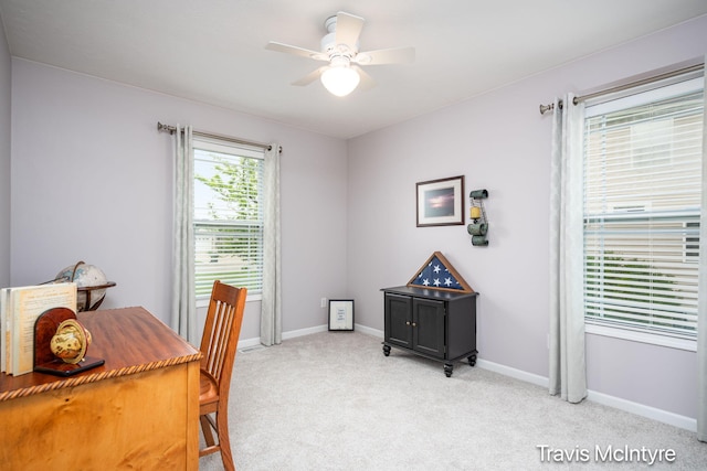 office space featuring light colored carpet, ceiling fan, and baseboards