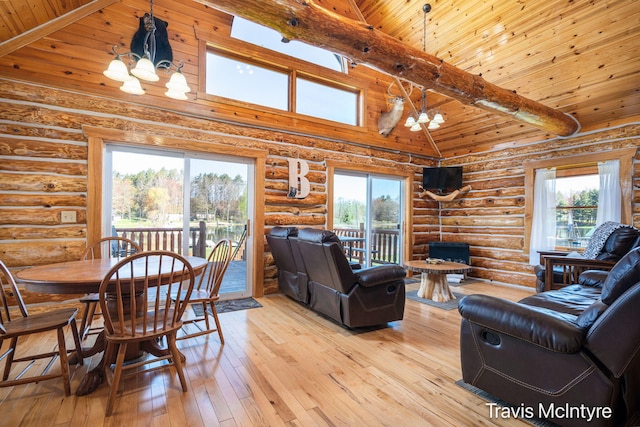 114 Horseshoe Dr, Leroy, MI 49655 - living room with a chandelier, rustic walls, light wood-style flooring, wood ceiling, and beamed ceiling