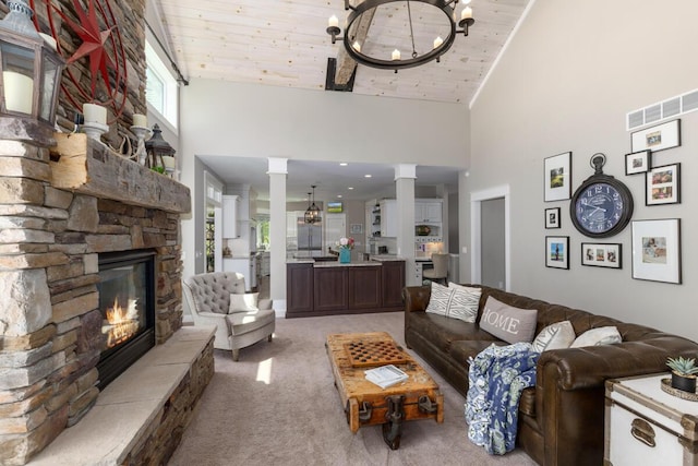 9510 Sparta Ave NW, Sparta, MI 49345 - living room featuring decorative columns, light colored carpet, a towering ceiling, a stone fireplace, and wood ceiling