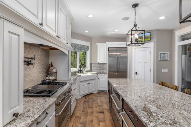 9510 Sparta Ave NW, Sparta, MI 49345 - kitchen with a sink, high quality appliances, dark wood-style flooring, white cabinets, and tasteful backsplash