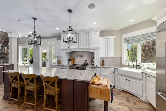 9510 Sparta Ave NW, Sparta, MI 49345 - kitchen with a sink, tasteful backsplash, a kitchen island, light wood-style floors, and recessed lighting
