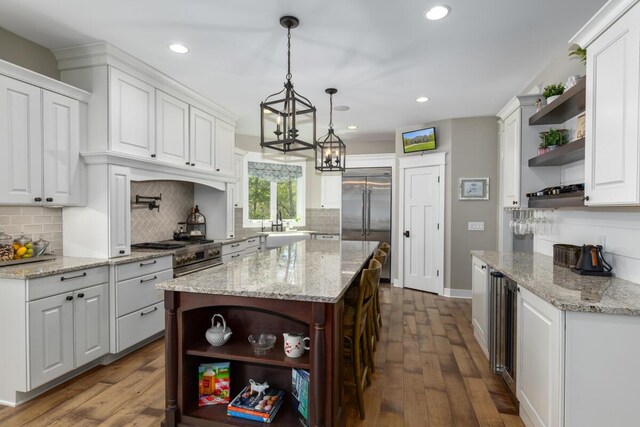 9510 Sparta Ave NW, Sparta, MI 49345 - kitchen with open shelves, stainless steel built in refrigerator, white cabinets, decorative backsplash, and recessed lighting