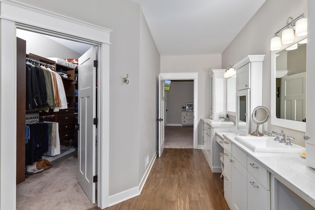 9510 Sparta Ave NW, Sparta, MI 49345 - bathroom with a walk in closet, vanity, baseboards, and wood finished floors