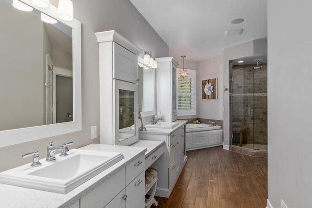 9510 Sparta Ave NW, Sparta, MI 49345 - full bathroom featuring a stall shower, wood finished floors, and two vanities
