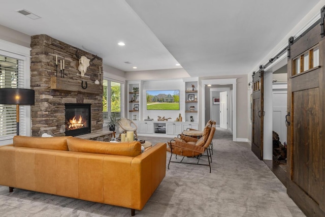 9510 Sparta Ave NW, Sparta, MI 49345 - living room with a barn door, light colored carpet, a stone fireplace, baseboards, and recessed lighting