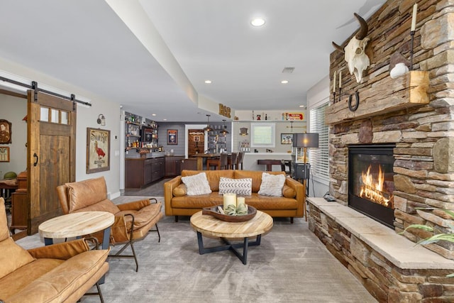 9510 Sparta Ave NW, Sparta, MI 49345 - living room featuring a stone fireplace, a barn door, recessed lighting, and bar area