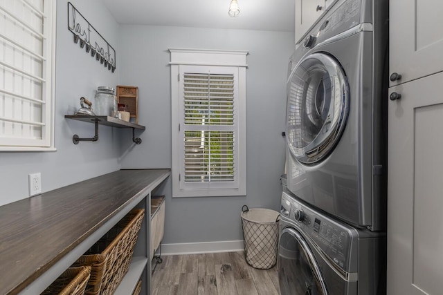 9510 Sparta Ave NW, Sparta, MI 49345 - clothes washing area featuring stacked washer / drying machine, wood finished floors, cabinet space, and baseboards