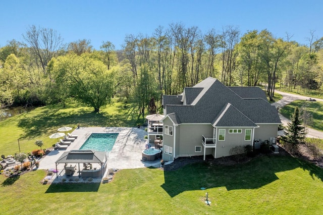 9510 Sparta Ave NW, Sparta, MI 49345 - back of house featuring a shingled roof, an outdoor pool, a lawn, and a patio area