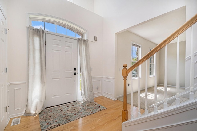 2570 Black Horse Ct NE, Grand Rapids, MI 49505 - entryway with stairway, light wood-style floors, a wainscoted wall, and a decorative wall