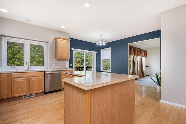 2570 Black Horse Ct NE, Grand Rapids, MI 49505 - kitchen with stainless steel dishwasher, light wood-style flooring, a center island, a sink, and baseboards