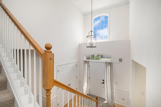 2570 Black Horse Ct NE, Grand Rapids, MI 49505 - entrance foyer featuring ornamental molding, a chandelier, stairs, a high ceiling, and baseboards