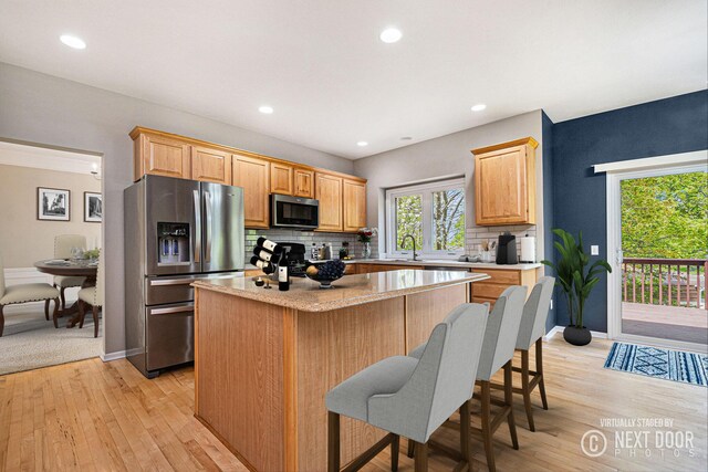 2570 Black Horse Ct NE, Grand Rapids, MI 49505 - kitchen featuring stainless steel appliances, a kitchen island, backsplash, light countertops, and recessed lighting