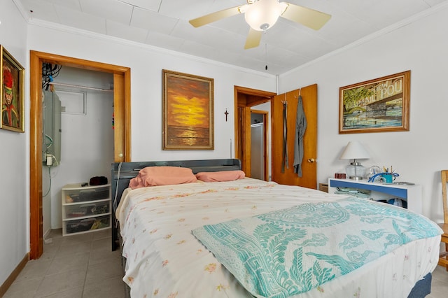 tiled bedroom featuring a closet, ornamental molding, baseboards, and ceiling fan